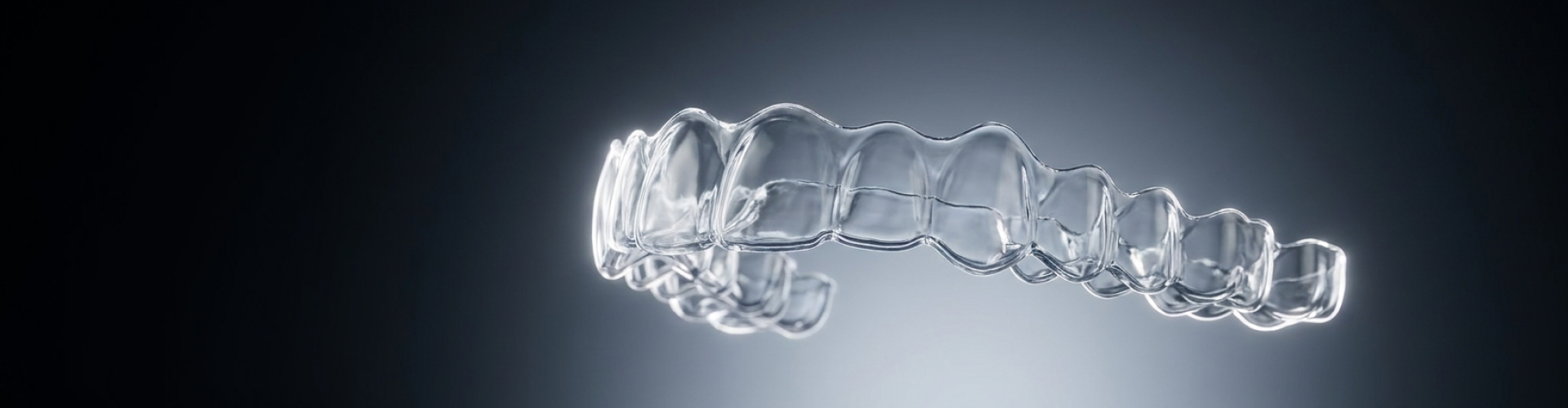 A transparent dental aligner shown against a dark background.